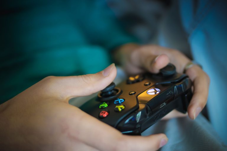 Hands gripping a modern wireless gaming controller indoors. Perfect for tech enthusiasts. — Direct Big Provider Slot Websites
