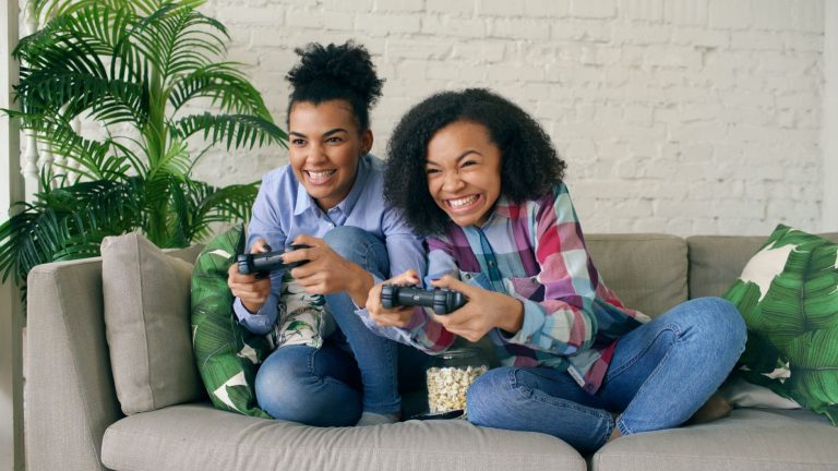 Two teenagers enjoying video games on a couch, showing excitement and joy. — Discover Nonstop Casino Entertainment and Real W