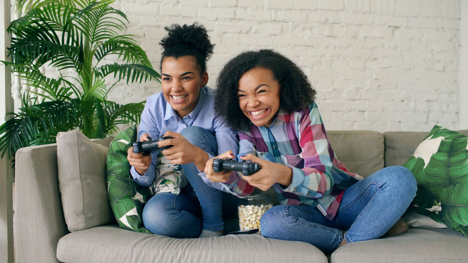 Two teenagers enjoying video games on a couch, showing excitement and joy. — Discover Nonstop Casino Entertainment and Real W