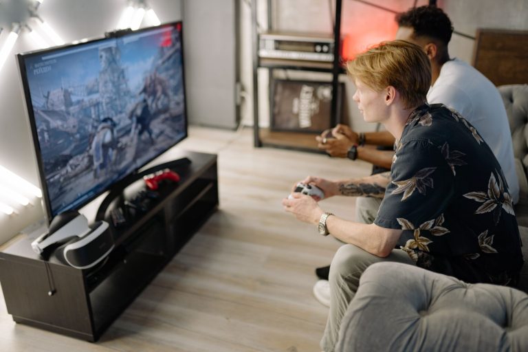Two friends immersed in playing video games together in a cozy living room. — Najlepsze recenzje kasyn kryptowalutowych
