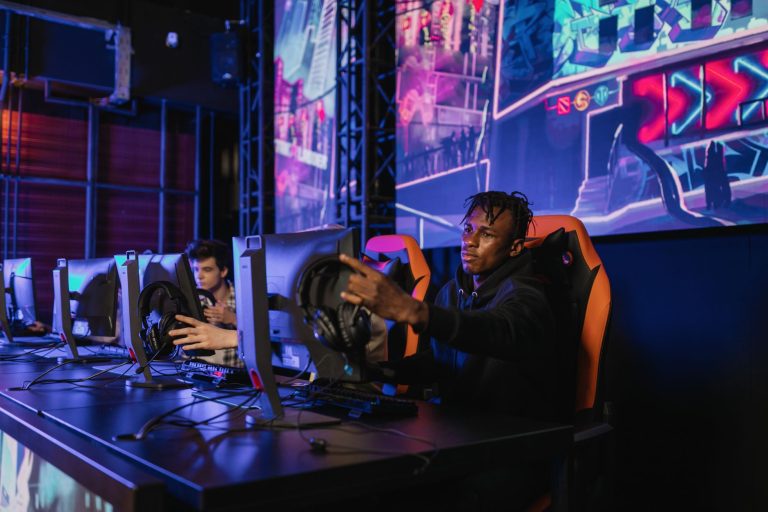 Two gamers intensely focused in a professional eSports competition with vibrant game visuals. — Play Baccarat Confidently on