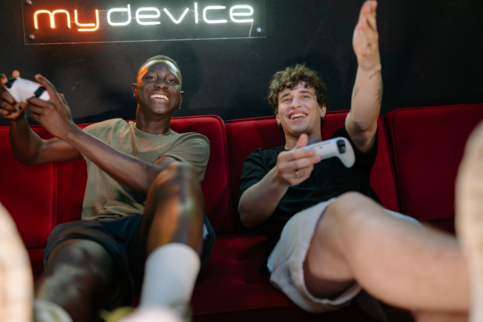 Two friends having fun and playing video games on a couch indoors. — Prijava bez putovnice za online igre u ovoj godini
